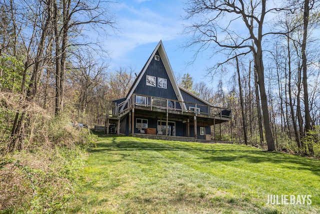rear view of house with a wooden deck and a yard