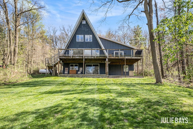 back of property with a deck, a yard, and stairway
