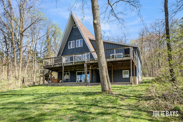 rear view of house featuring a deck, a lawn, and stairs