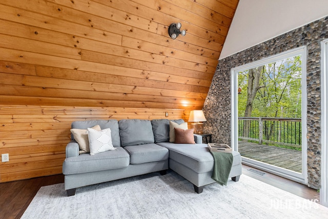 living area featuring wood finished floors, lofted ceiling, wooden walls, and wooden ceiling