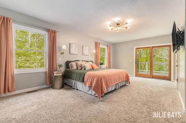 carpeted bedroom with access to outside, a chandelier, baseboards, and multiple windows