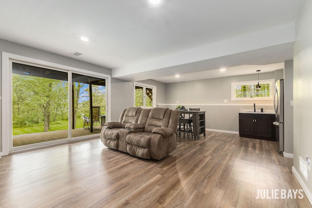 living room with dark wood-type flooring, baseboards, and recessed lighting