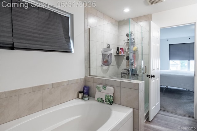 9480 White Tail Dr, Ypsilanti, MI 48197 - bathroom featuring a stall shower, a bath, wood finished floors, connected bathroom, and recessed lighting