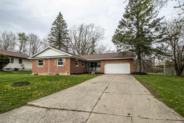 single story home with brick siding, a garage, a front lawn, and driveway