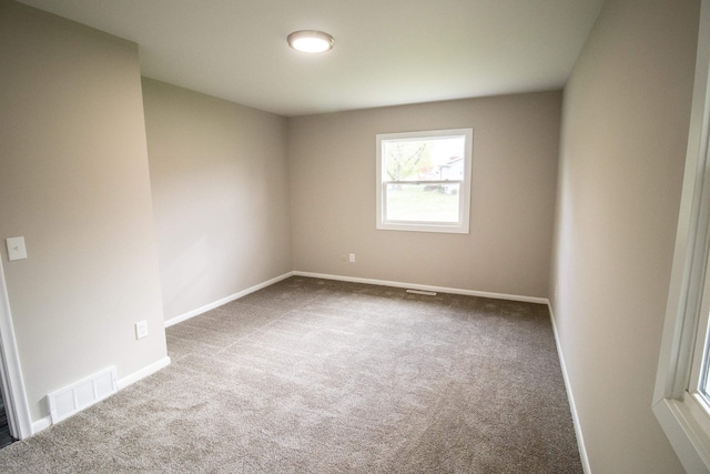 unfurnished room featuring carpet floors and baseboards
