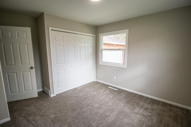 unfurnished bedroom featuring carpet floors, baseboards, and a closet