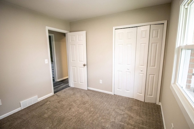 unfurnished bedroom featuring carpet floors, a closet, and baseboards