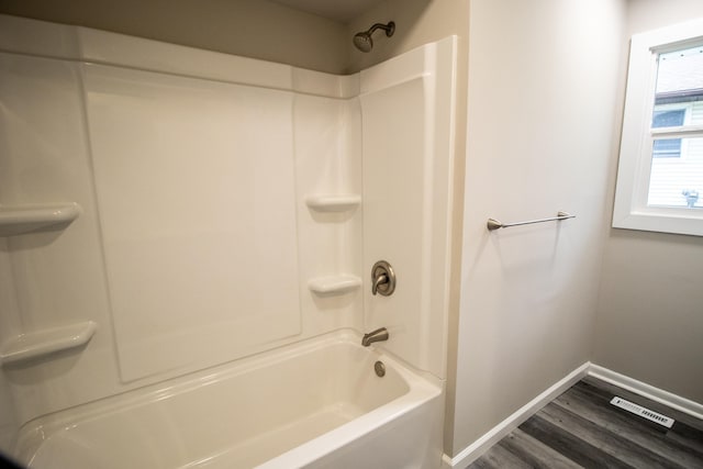 full bathroom featuring wood finished floors, baseboards, and tub / shower combination
