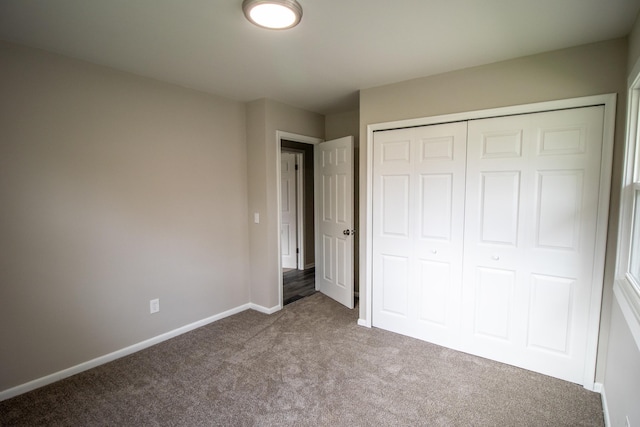 unfurnished bedroom featuring carpet, a closet, and baseboards