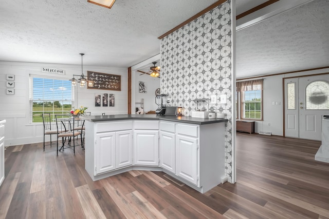 10060 Pioneer Rd, Hillsdale, MI 49242 - kitchen with a textured ceiling, dark countertops, a chandelier, white cabinetry, and dark wood-style floors