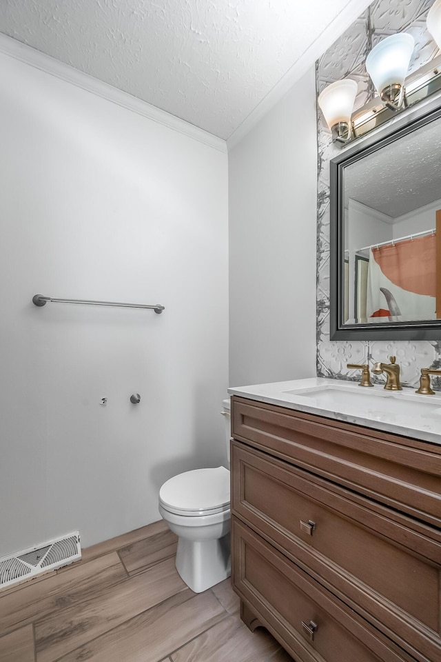 10060 Pioneer Rd, Hillsdale, MI 49242 - bathroom featuring toilet, ornamental molding, vanity, a textured ceiling, and wood finished floors