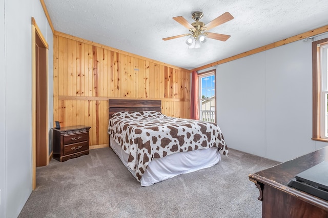 10060 Pioneer Rd, Hillsdale, MI 49242 - carpeted bedroom with wooden walls, a textured ceiling, and ceiling fan