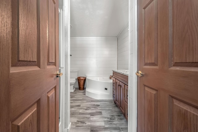 10060 Pioneer Rd, Hillsdale, MI 49242 - bathroom featuring toilet, wood finished floors, a tub, vanity, and wood walls
