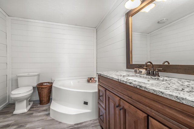 10060 Pioneer Rd, Hillsdale, MI 49242 - bathroom with wood finished floors, wood walls, a bath, vanity, and toilet