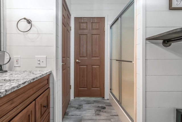 10060 Pioneer Rd, Hillsdale, MI 49242 - full bath featuring a shower stall, vanity, and wood finished floors