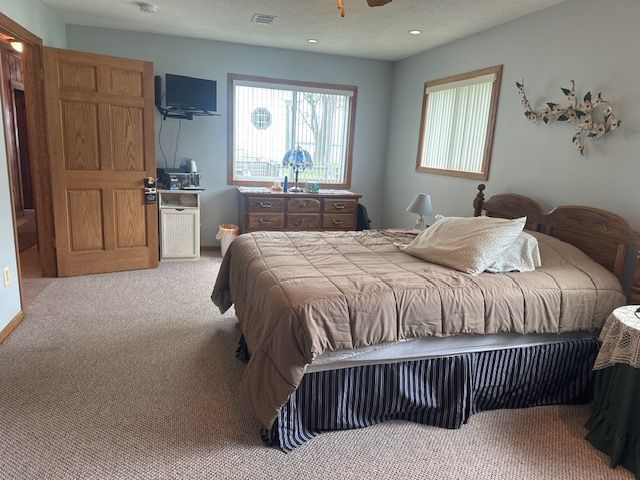 bedroom with light carpet and recessed lighting