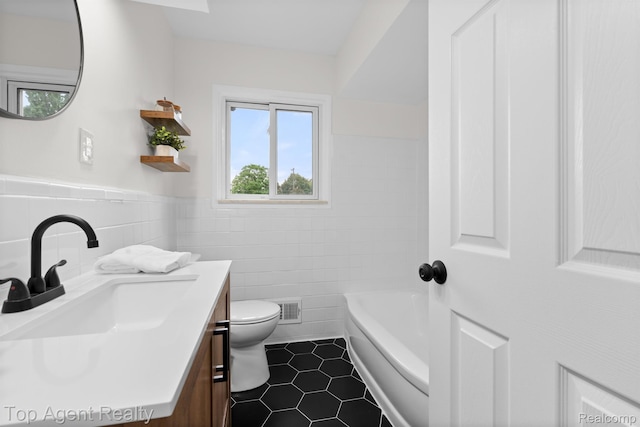 32525 Holden Dr, Warren, MI 48092 - full bathroom featuring vanity, toilet, tile walls, a tub to relax in, and tile patterned flooring