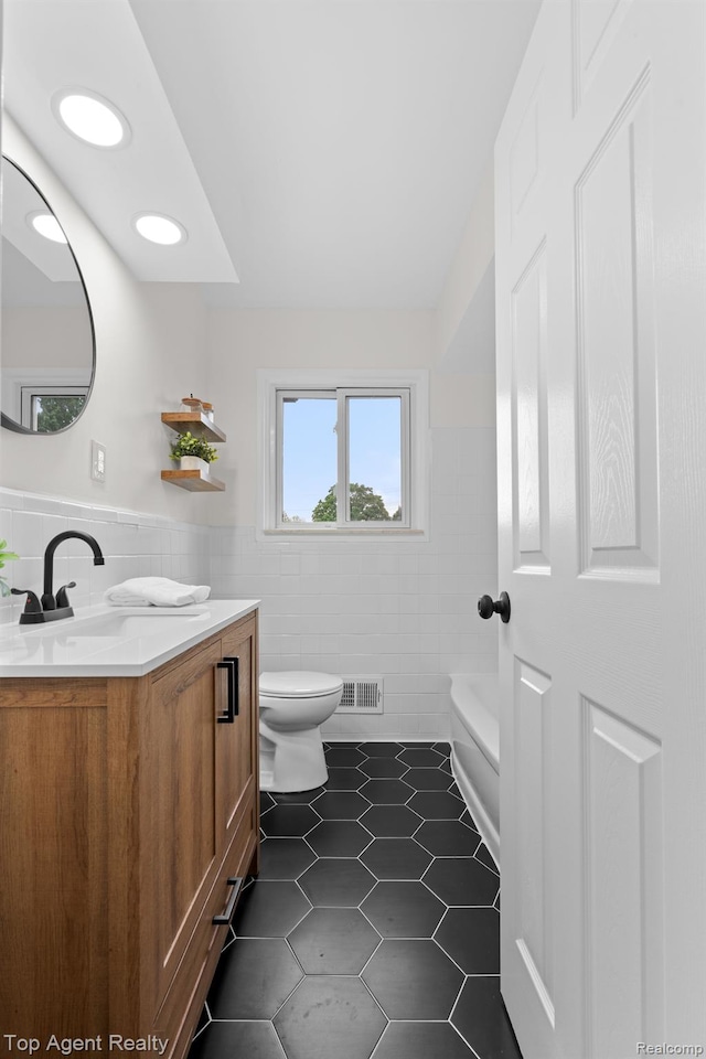 32525 Holden Dr, Warren, MI 48092 - bathroom featuring tile walls, tile patterned floors, vanity, toilet, and a tub
