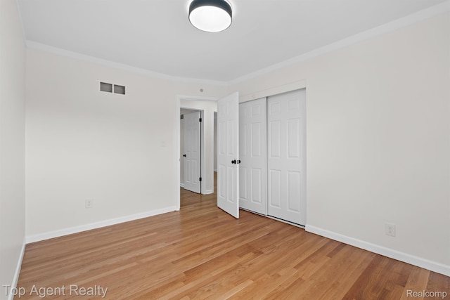 32525 Holden Dr, Warren, MI 48092 - unfurnished bedroom featuring light wood-style flooring, baseboards, a closet, and crown molding
