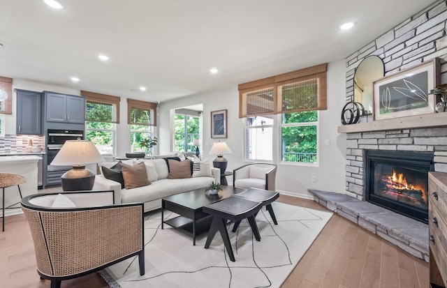 5136 Barnes Rd, Canton, MI 48188 - living room with a stone fireplace, recessed lighting, light wood-style floors, and baseboards