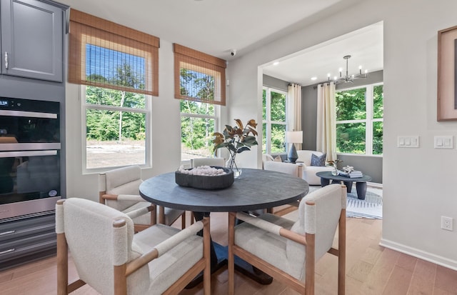 5136 Barnes Rd, Canton, MI 48188 - dining room featuring light wood-style flooring, a chandelier, baseboards, and healthy amount of natural light