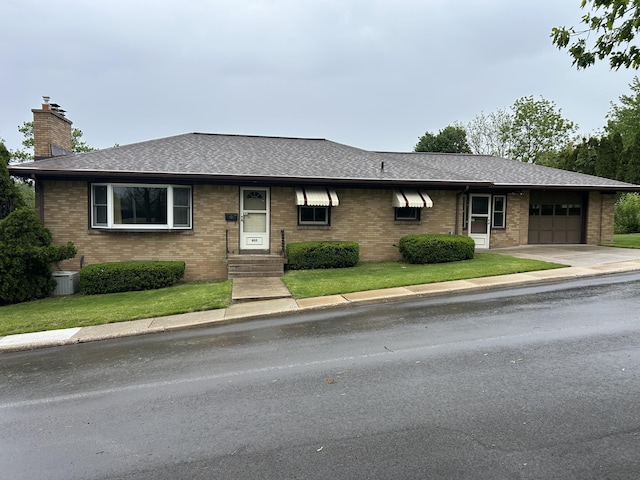 805 Capen St NE, Grand Rapids, MI 49505 - ranch-style house with brick siding, a garage, a shingled roof, and a chimney