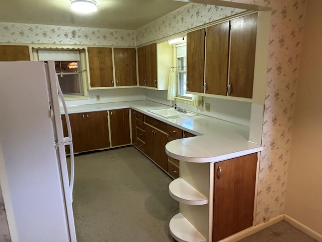 805 Capen St NE, Grand Rapids, MI 49505 - kitchen with freestanding refrigerator, a sink, wallpapered walls, light countertops, and baseboards