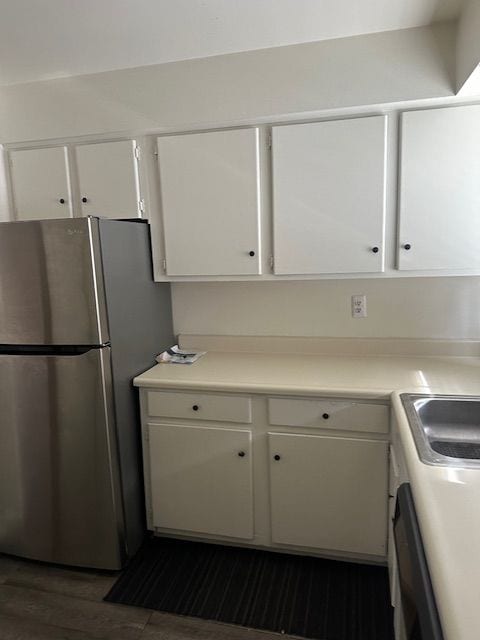 25332 Shiawassee Cir, Southfield, MI 48033 - kitchen featuring freestanding refrigerator, white cabinets, dark wood-style flooring, light countertops, and a sink