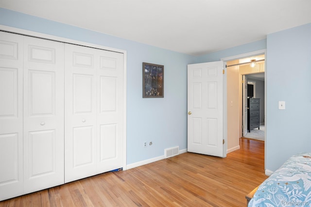 2960 Timberwyck Trail Dr, Troy, MI 48098 - unfurnished bedroom with baseboards, light wood-style floors, a closet, and a barn door