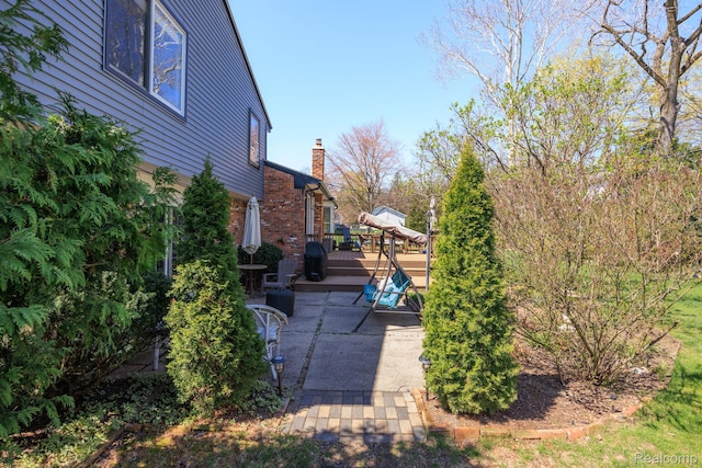 2960 Timberwyck Trail Dr, Troy, MI 48098 - view of side of property with a patio, a deck, brick siding, and a chimney