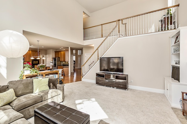 2129 Autumn Hill Dr, Ann Arbor, MI 48103 - living area with a high ceiling, stairway, baseboards, and light colored carpet