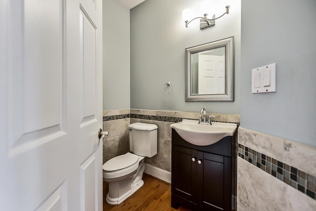 2129 Autumn Hill Dr, Ann Arbor, MI 48103 - bathroom featuring a wainscoted wall, tile walls, toilet, vanity, and wood finished floors