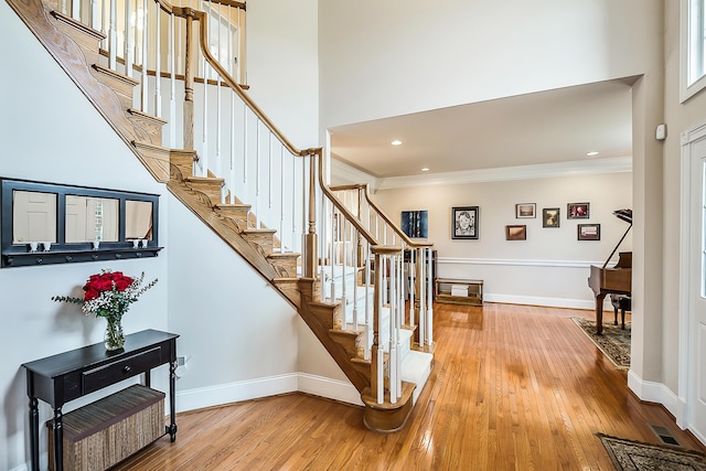 2129 Autumn Hill Dr, Ann Arbor, MI 48103 - stairs featuring hardwood / wood-style flooring, ornamental molding, baseboards, a high ceiling, and recessed lighting