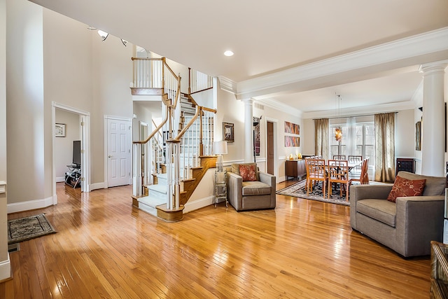 2129 Autumn Hill Dr, Ann Arbor, MI 48103 - living area with ornate columns, light wood finished floors, crown molding, stairway, and baseboards
