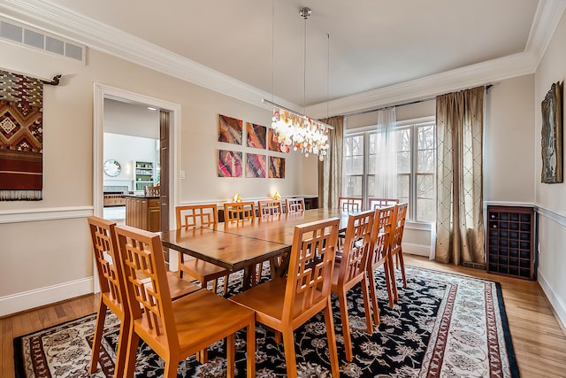 2129 Autumn Hill Dr, Ann Arbor, MI 48103 - dining room featuring crown molding, light wood-type flooring, a chandelier, and baseboards