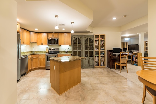 2129 Autumn Hill Dr, Ann Arbor, MI 48103 - kitchen with appliances with stainless steel finishes, a kitchen island, backsplash, dark stone countertops, and decorative light fixtures