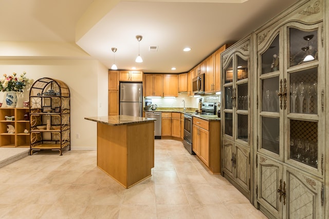 2129 Autumn Hill Dr, Ann Arbor, MI 48103 - kitchen featuring appliances with stainless steel finishes, a kitchen island, recessed lighting, decorative light fixtures, and dark stone countertops