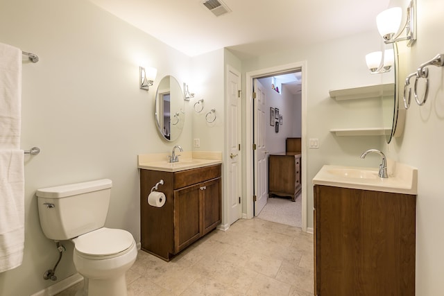 2129 Autumn Hill Dr, Ann Arbor, MI 48103 - bathroom with toilet, two vanities, and baseboards
