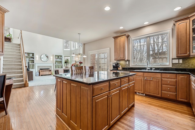 2129 Autumn Hill Dr, Ann Arbor, MI 48103 - kitchen with a sink, light wood-type flooring, brown cabinetry, dark stone counters, and backsplash