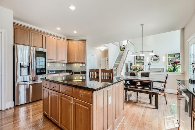 2129 Autumn Hill Dr, Ann Arbor, MI 48103 - kitchen featuring stainless steel fridge, light wood-style flooring, dark stone countertops, tasteful backsplash, and recessed lighting