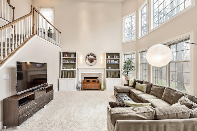 2129 Autumn Hill Dr, Ann Arbor, MI 48103 - carpeted living area with a towering ceiling, a tiled fireplace, and baseboards