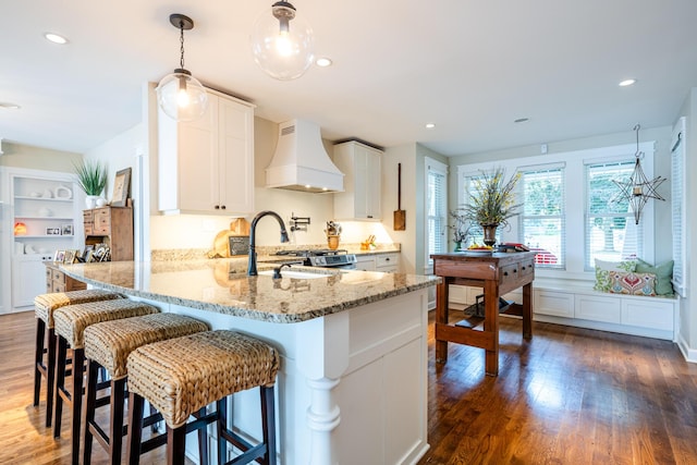 7881 Lakewood Dr, Coloma, MI 49038 - kitchen with custom exhaust hood, wood finished floors, white cabinetry, a peninsula, and recessed lighting