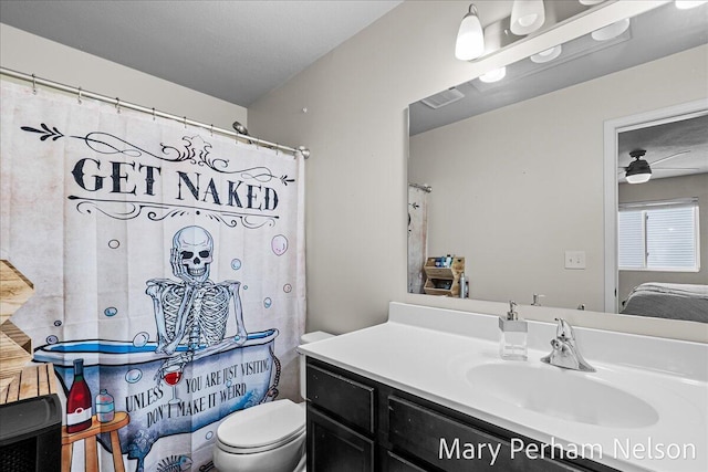 bathroom with toilet, vanity, and a ceiling fan