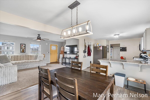 dining area featuring ceiling fan, light wood-type flooring, and baseboards