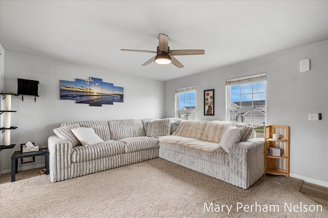 living room with ceiling fan and baseboards