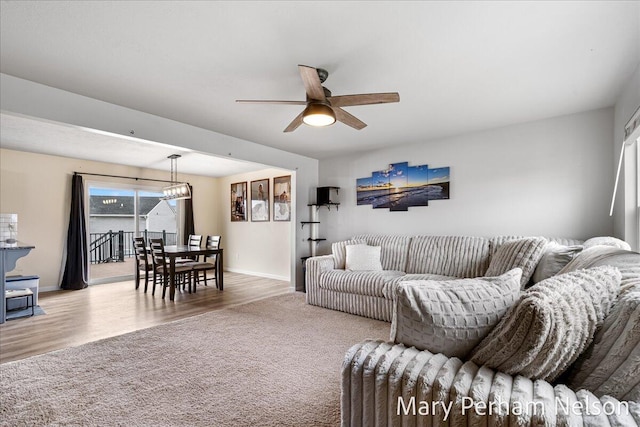 living room featuring ceiling fan, wood finished floors, and baseboards