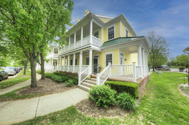 254 Constitution St, Canton, MI 48188 - view of front of house with covered porch, a balcony, a standing seam roof, metal roof, and a front lawn