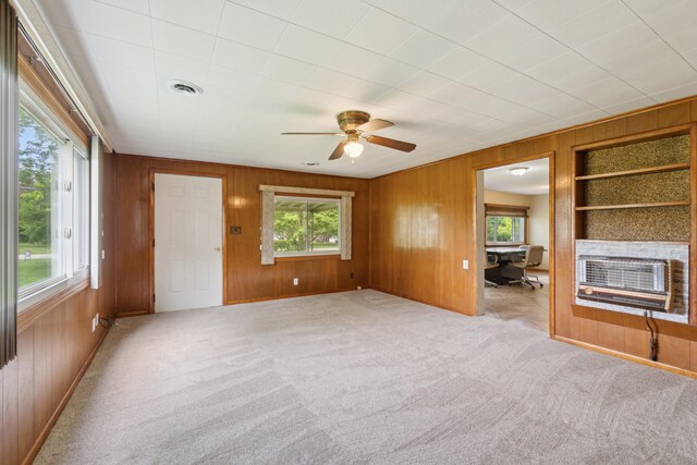 5277 Kay Dr, Jackson, MI 49203 - carpeted empty room with wooden walls, healthy amount of natural light, ceiling fan, and heating unit