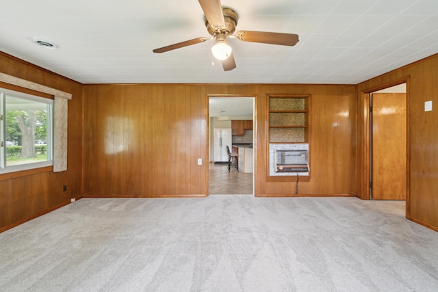 5277 Kay Dr, Jackson, MI 49203 - spare room featuring heating unit, wood walls, carpet floors, a ceiling fan, and baseboards