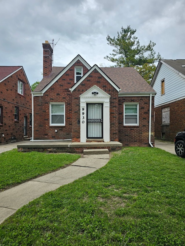9930 Balfour Rd, Detroit, MI 48224 - view of front facade featuring brick siding, a front yard, a chimney, and a shingled roof